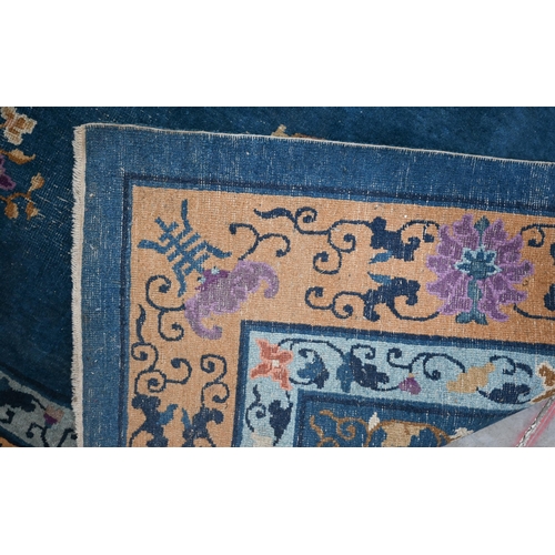 128 - A Mid-Century Chinese Peking carpet, scattered design with floral sprays and roundels on blue ground... 