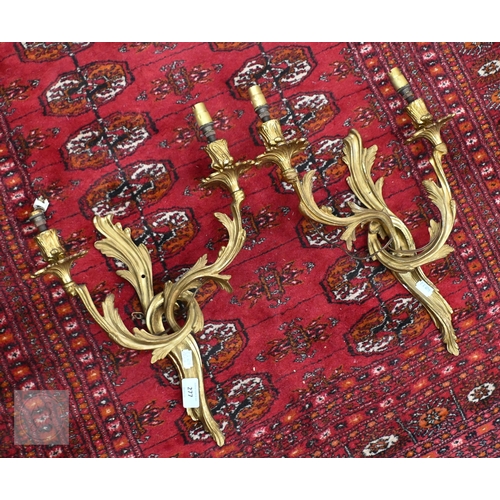 277 - A pair of Rococo style gilt metal twin branch asymmetric design wall sconces, 45 cm h