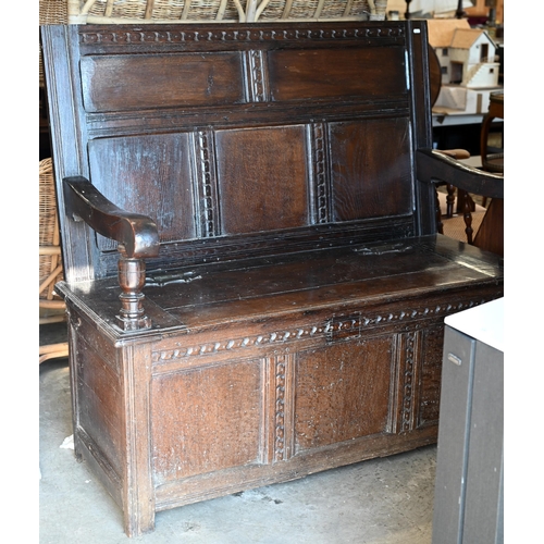 283 - An antique oak box seated settle, panelled construction with carved vertical and horizontal frame wo... 