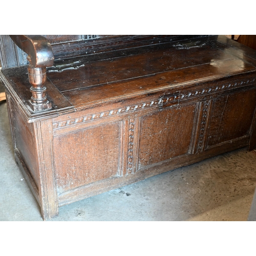 283 - An antique oak box seated settle, panelled construction with carved vertical and horizontal frame wo... 