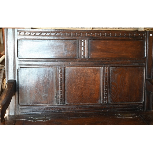 283 - An antique oak box seated settle, panelled construction with carved vertical and horizontal frame wo... 