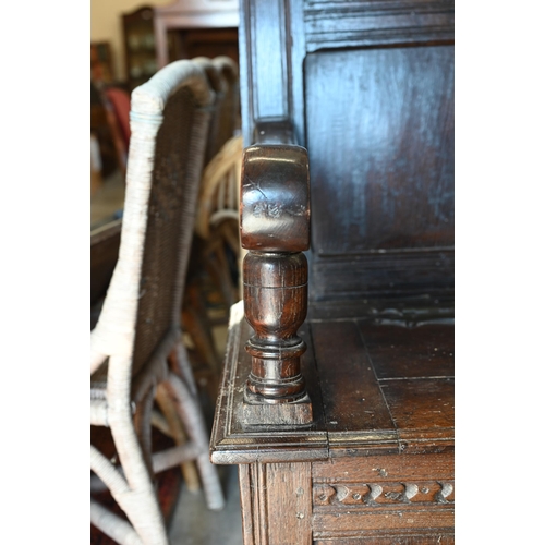 283 - An antique oak box seated settle, panelled construction with carved vertical and horizontal frame wo... 