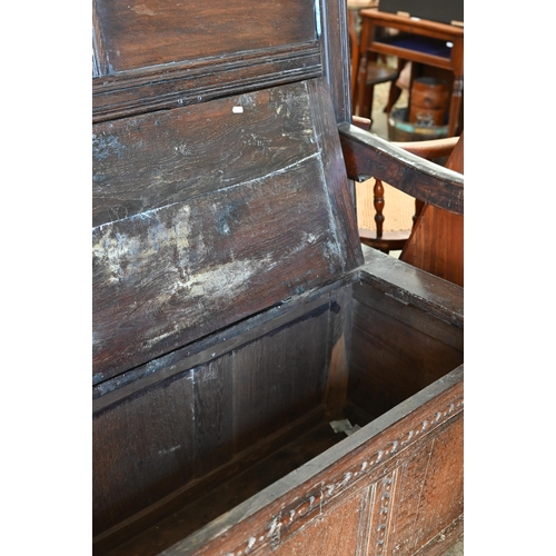 283 - An antique oak box seated settle, panelled construction with carved vertical and horizontal frame wo... 