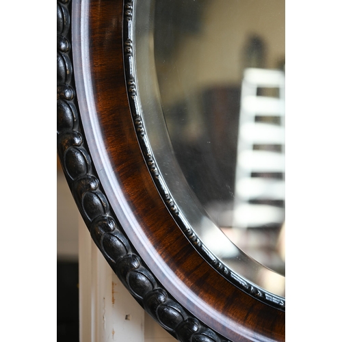 298 - Oval bevelled wall mirror in carved and moulded mahogany frame, 64 x 54 cm