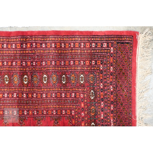 62 - A Pakistani Turkoman design rug with repeat gul design on red ground, to/w a Ghanaian blanket, 244 x... 