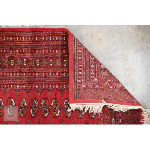 62 - A Pakistani Turkoman design rug with repeat gul design on red ground, to/w a Ghanaian blanket, 244 x... 