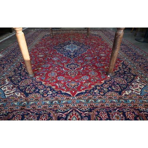 295 - Large Central Persian Kashan carpet, traditional floral design on red ground within conforming blue ... 