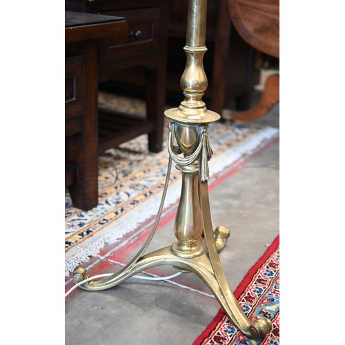 296 - A polished brass standard lamp on scrolling triform base with Neoclassical ribbon swags, 180 cm h