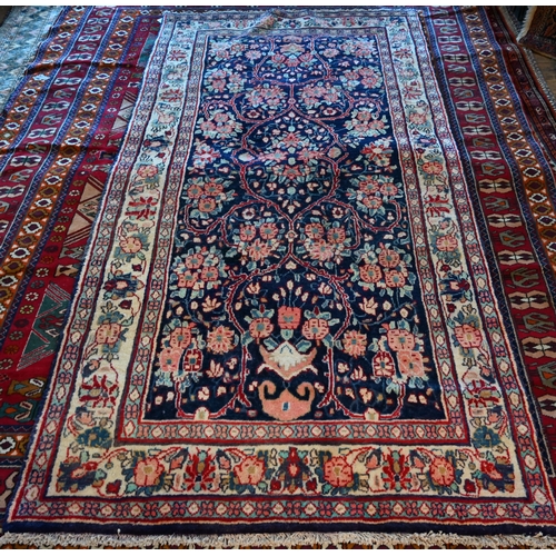 634 - A North West Persian Sarouk rug, floral design on blue ground, cream border with alternating rosette... 