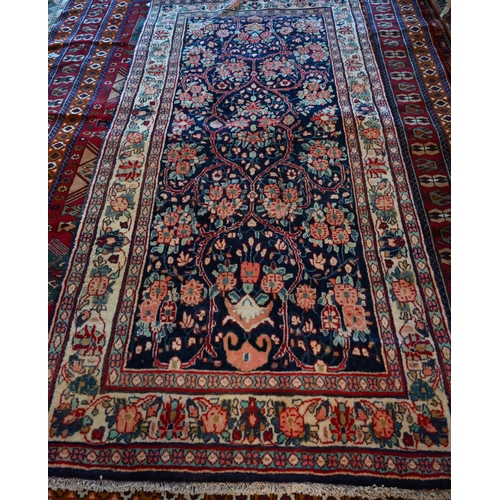 634 - A North West Persian Sarouk rug, floral design on blue ground, cream border with alternating rosette... 