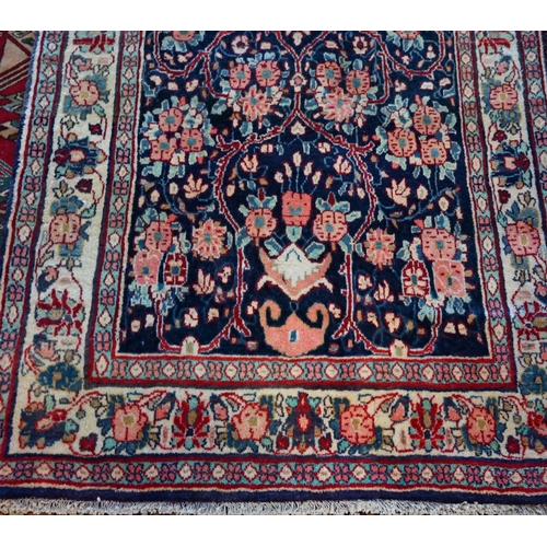 634 - A North West Persian Sarouk rug, floral design on blue ground, cream border with alternating rosette... 