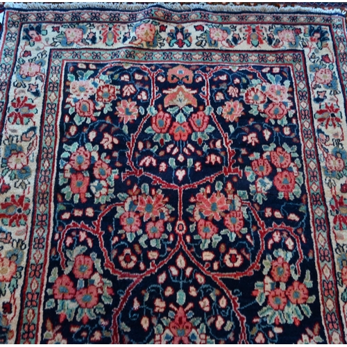 634 - A North West Persian Sarouk rug, floral design on blue ground, cream border with alternating rosette... 