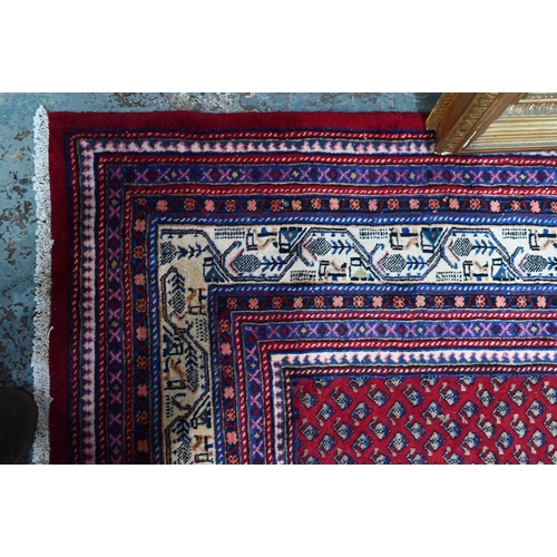 636 - A North West Persian Arak carpet, the repeating floral design on red ground, 315 cm x 215 cm
