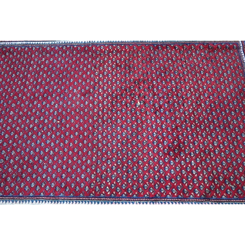 636 - A North West Persian Arak carpet, the repeating floral design on red ground, 315 cm x 215 cm