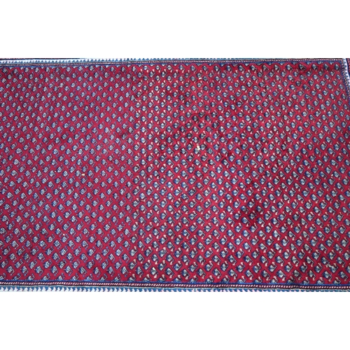 636 - A North West Persian Arak carpet, the repeating floral design on red ground, 315 cm x 215 cm
