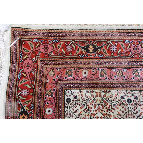 638 - A fine Hereke handmade carpet, all over design on cream ground within red/pink borders 287 x 203 cm