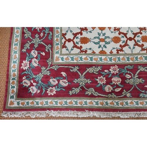 643 - An Indo-Persian Agra carpet with floral herati design on camel ground with red floral scroll border,... 