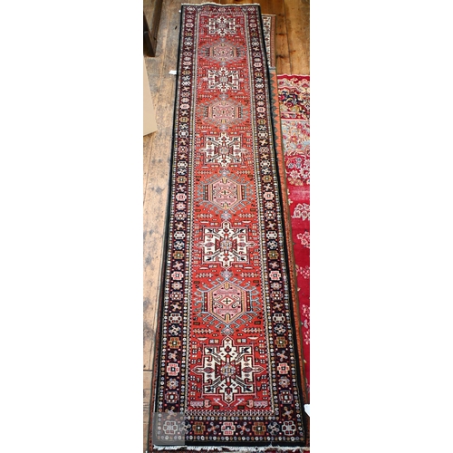 651 - A contemporary handmade Persian Karaja runner, the geometric pole design on red ground, 397 cm x cm ... 