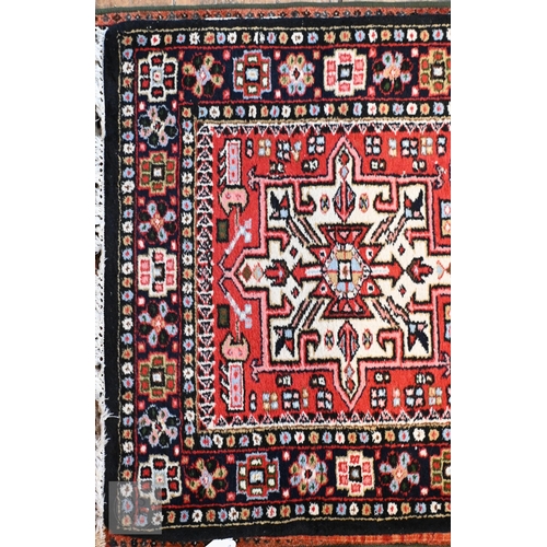651 - A contemporary handmade Persian Karaja runner, the geometric pole design on red ground, 397 cm x cm ... 