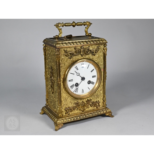 677 - A Continental profusely-chased brass mantel clock, the 8-day two train movement striking the hours a... 