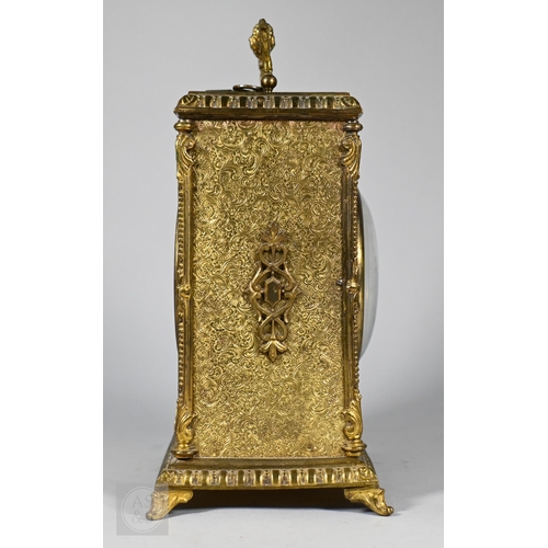 677 - A Continental profusely-chased brass mantel clock, the 8-day two train movement striking the hours a... 