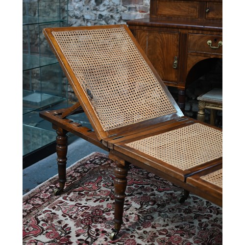 577 - A Victorian cane panelled campaign day bed, raised on turned legs to brass castors, with green leath... 