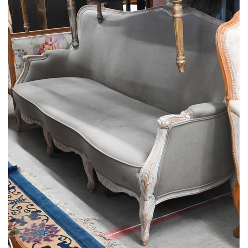 A French Louis XV style three seater settee with limewashed carved beech frame and dove-grey upholstery