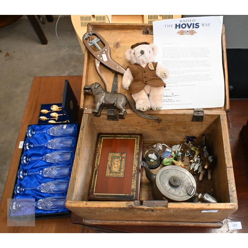 557 - A vintage wooden ditty box and contents including cast metal 'dog' nutcrackers, glass miniature anim... 