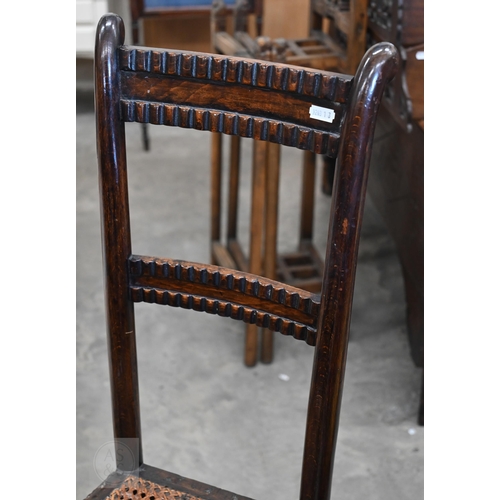 587 - A Victorian stained beech cane seated correction chair on turned legs