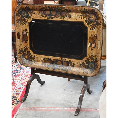 588 - A black metal folding tray-top table with gilt and polychrome flowers and fruit decoration