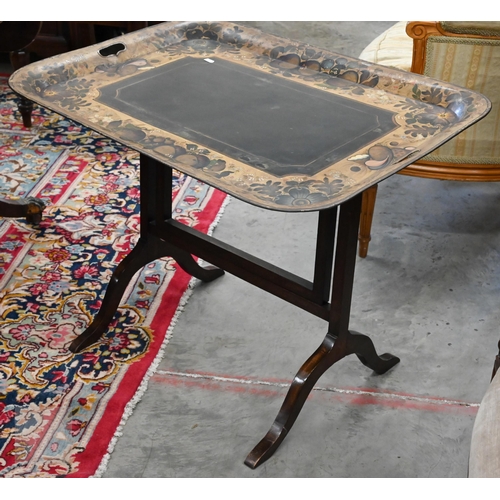 588 - A black metal folding tray-top table with gilt and polychrome flowers and fruit decoration