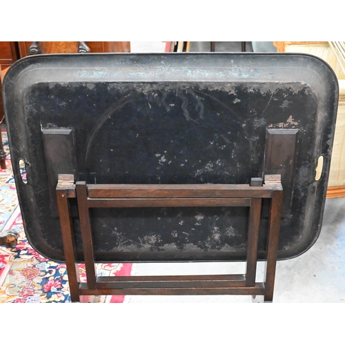 588 - A black metal folding tray-top table with gilt and polychrome flowers and fruit decoration