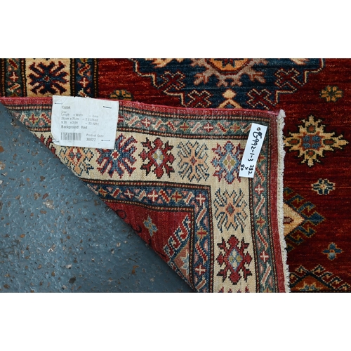 595 - A Persian Kazhak runner with geometric medallions on red ground with blue and beige borders, 282 x 8... 