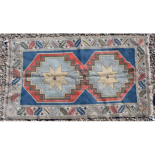 596 - A Turkish Milas geometric design rug with double star medallion on blue ground with leaf and rosette... 