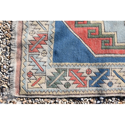 596 - A Turkish Milas geometric design rug with double star medallion on blue ground with leaf and rosette... 