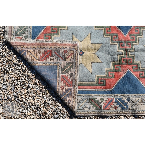 596 - A Turkish Milas geometric design rug with double star medallion on blue ground with leaf and rosette... 