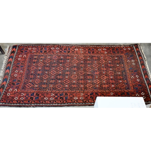 599 - A vintage Persian Balouch rug with tessalating octagonal motif on red ground, 176 x 96 cm to/w a Per... 