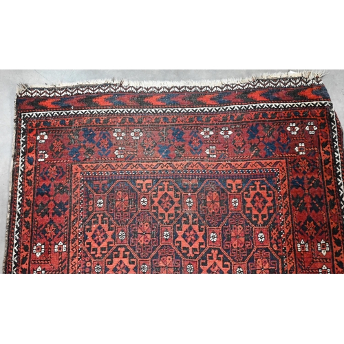 599 - A vintage Persian Balouch rug with tessalating octagonal motif on red ground, 176 x 96 cm to/w a Per... 