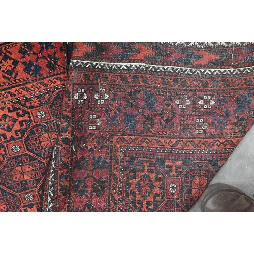 599 - A vintage Persian Balouch rug with tessalating octagonal motif on red ground, 176 x 96 cm to/w a Per... 