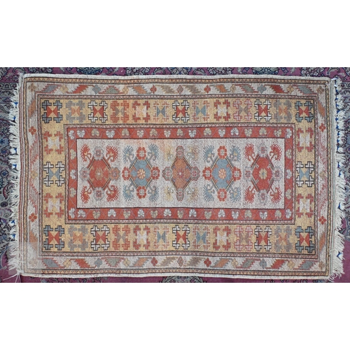 601 - A Turkish Milas cream ground rug with floral diamond medallions and yellow border, 182 x 121 cm to/w... 