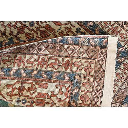 605 - An antique Persian Shirvan rug, beige ground with blue borders, 134 x 99 cm