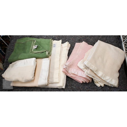 573 - A selection of pink and cream woollen cellular and solid weave blankets, some with satin edging, var... 