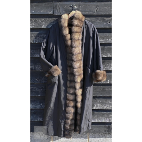 574 - A fur-timmed reversible long coat in black to/w a mid length fox fur jacket (2)