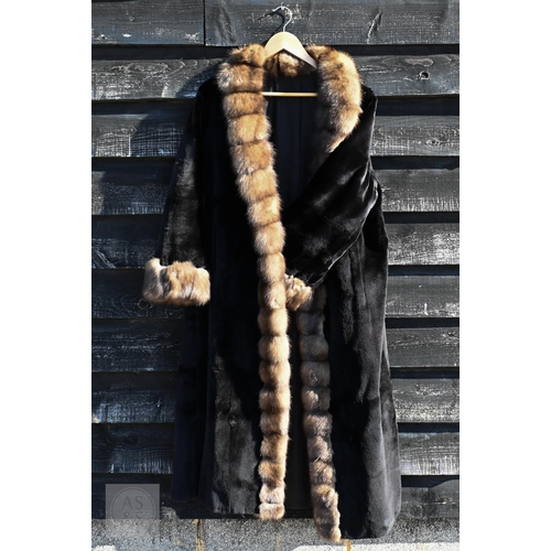 574 - A fur-timmed reversible long coat in black to/w a mid length fox fur jacket (2)
