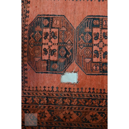 591 - An old Afghan rug with five medallions on pale red ground, 209 x 120 cm