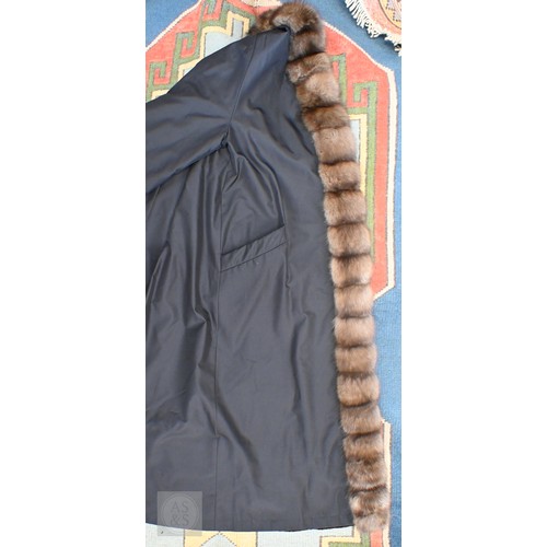 574 - A fur-timmed reversible long coat in black to/w a mid length fox fur jacket (2)