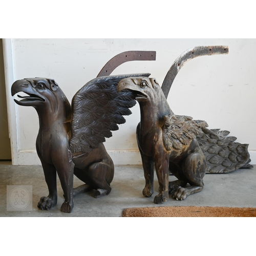 134 - A pair of antique carved hardwood gryphon table pedestals, a/f - old repairs with iron wing braces, ...