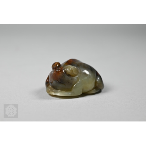 An 18th century Chinese celadon and russet jade recumbent toad, Qing dynasty, 3.5 cm wide 