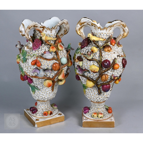 335 - A pair of 19th century porcelain floral-encrusted vases, applied with birds and fruit, on square bas...