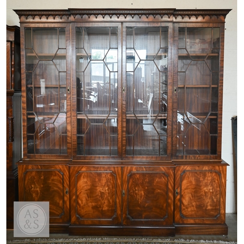 A large mahogany reproduction breakfront library bookcase with four astragal glazed doors over panelled cupboards and plinth base, possibly by Bevan Funnell (two sections), 202 x 39 x 215 cm high